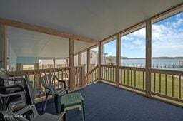 unfurnished sunroom featuring a water view