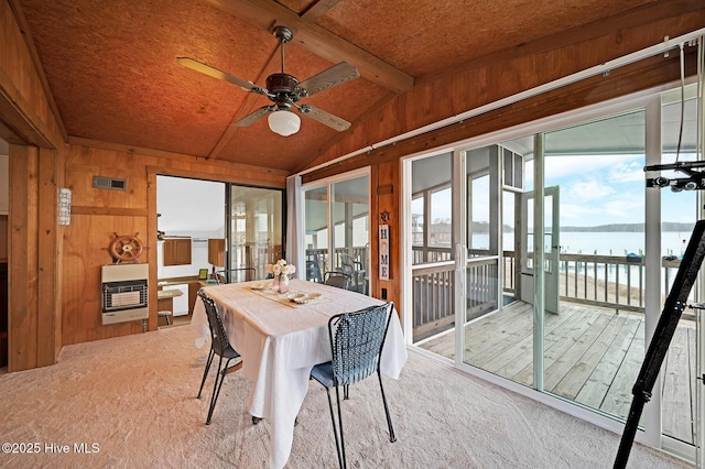 sunroom with heating unit, visible vents, vaulted ceiling with beams, ceiling fan, and a water view