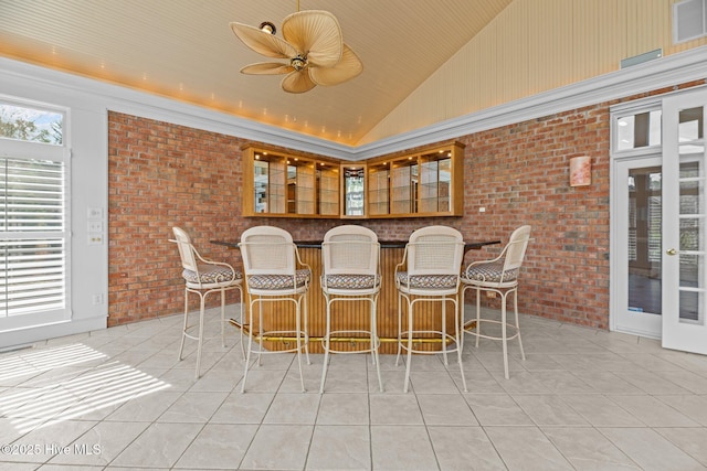 interior space with lofted ceiling, ceiling fan, and a dry bar