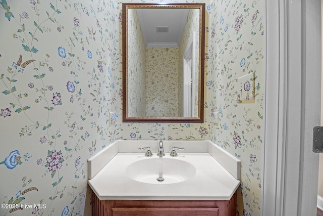 bathroom with wallpapered walls, visible vents, and vanity