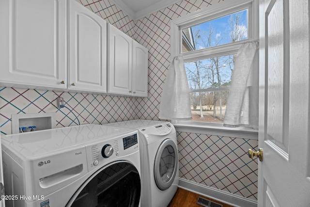 laundry room featuring plenty of natural light, washer and dryer, visible vents, and cabinet space