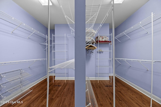 walk in closet with wood finished floors