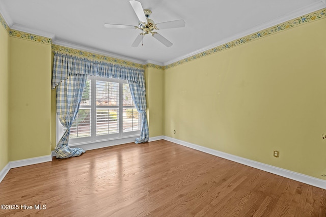 unfurnished room featuring baseboards, wood finished floors, a ceiling fan, and crown molding