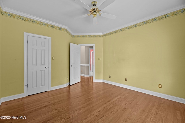 unfurnished bedroom featuring a ceiling fan, baseboards, wood finished floors, and ornamental molding