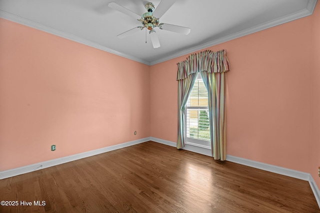 empty room featuring ceiling fan, baseboards, wood finished floors, and crown molding