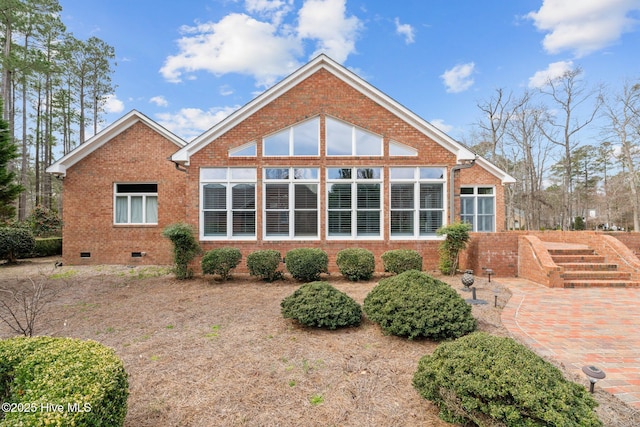 rear view of property with crawl space and brick siding