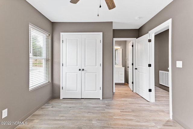 unfurnished bedroom with ceiling fan, connected bathroom, light wood-style flooring, visible vents, and baseboards