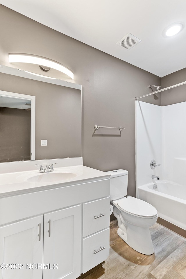 full bath featuring visible vents, vanity, toilet, and wood finished floors