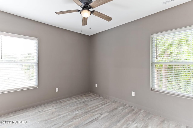 unfurnished room featuring a ceiling fan, baseboards, visible vents, and light wood finished floors