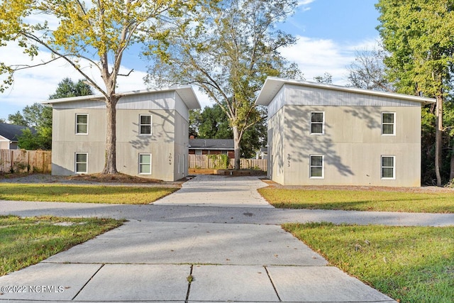 view of home's exterior with a lawn, driveway, and fence