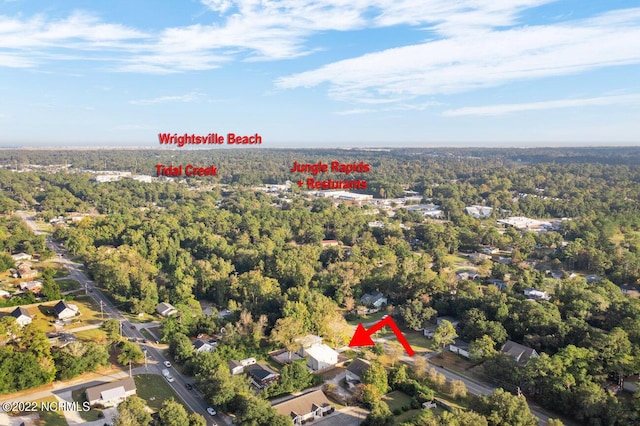 birds eye view of property featuring a view of trees