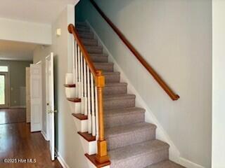 staircase featuring baseboards and wood finished floors