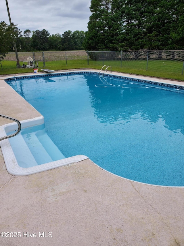 view of swimming pool featuring a fenced in pool, a lawn, and fence