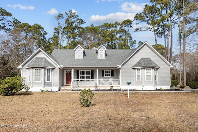 view of front facade featuring covered porch and a shingled roof