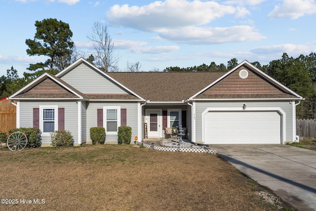 view of front of house featuring driveway, a garage, a shingled roof, fence, and a front yard