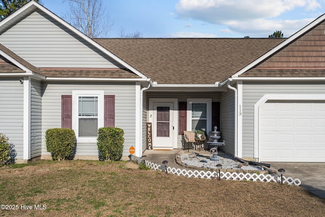 view of front of property featuring a shingled roof, a front lawn, and an attached garage