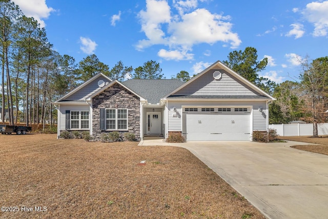 craftsman inspired home with driveway, stone siding, an attached garage, and fence