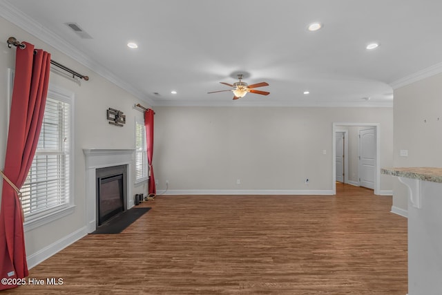 unfurnished living room featuring a fireplace with flush hearth, ornamental molding, and wood finished floors