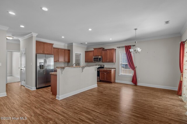 kitchen with dark wood finished floors, a center island, stainless steel appliances, a kitchen bar, and a chandelier