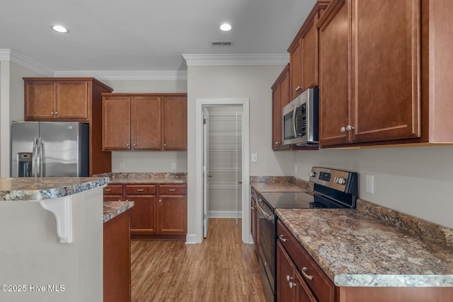 kitchen featuring appliances with stainless steel finishes, light wood-style floors, visible vents, and crown molding