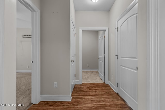 hallway featuring baseboards and wood finished floors