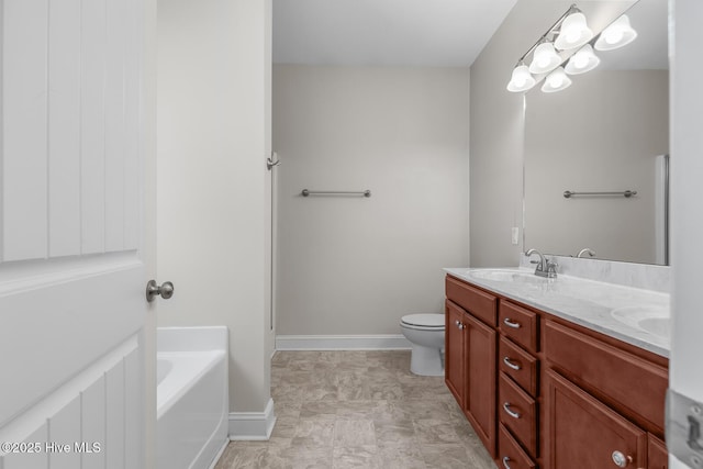 bathroom with toilet, a sink, baseboards, a bath, and double vanity