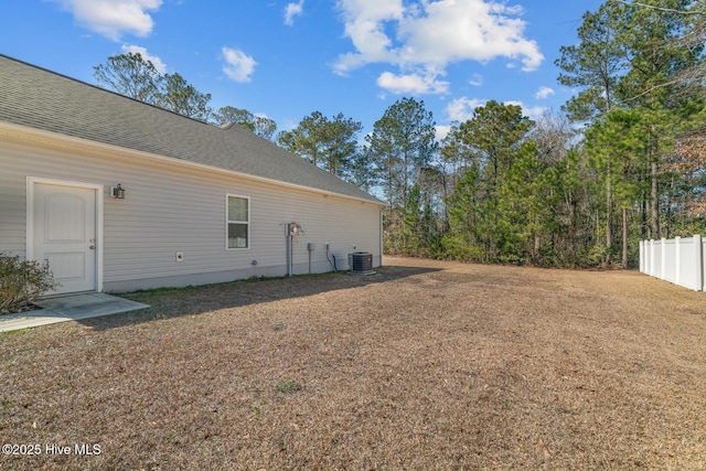 view of yard featuring fence and central air condition unit