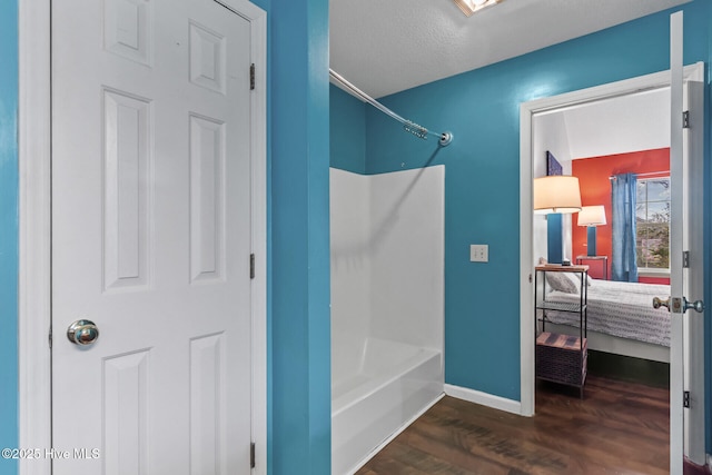 bathroom with shower / bathtub combination, wood finished floors, and baseboards