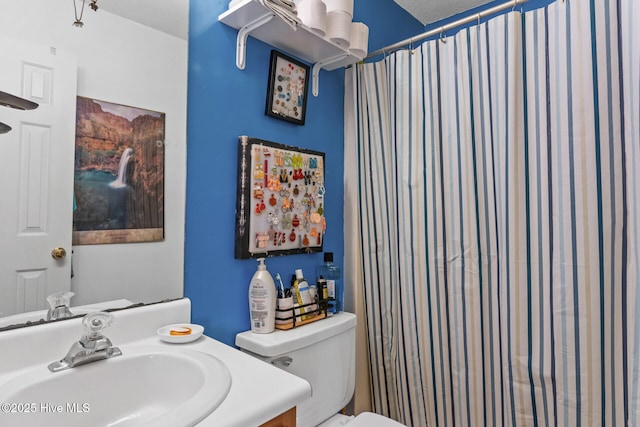 bathroom with curtained shower, vanity, and toilet