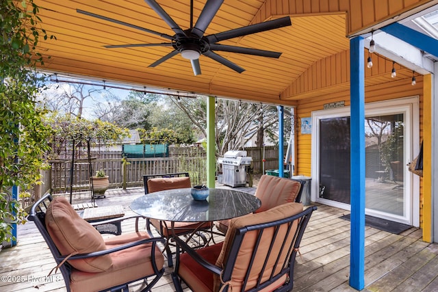 wooden terrace featuring a ceiling fan, outdoor dining space, fence, and grilling area