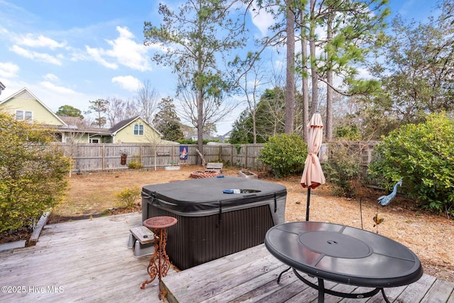 wooden deck with a fenced backyard and a hot tub