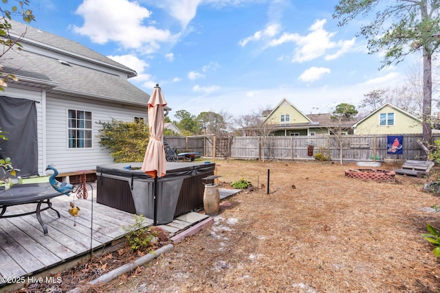 view of yard featuring a deck, a fenced backyard, and a hot tub