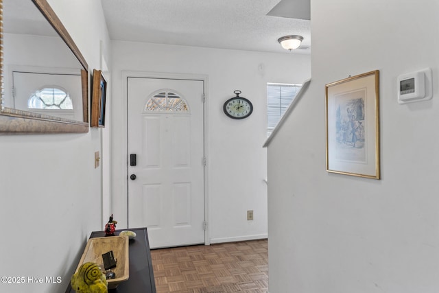 entryway with a textured ceiling and plenty of natural light