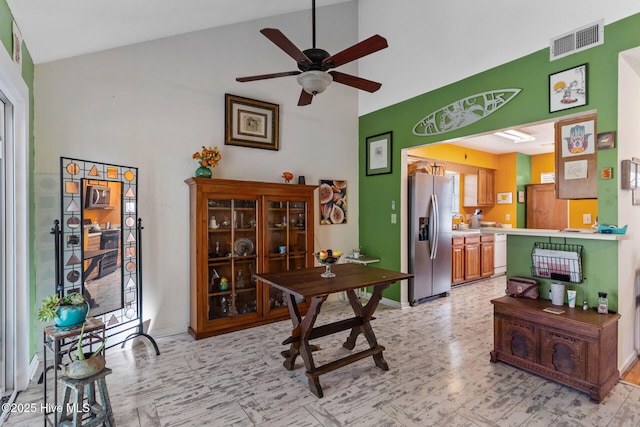 office area with baseboards, visible vents, a ceiling fan, vaulted ceiling, and a sink