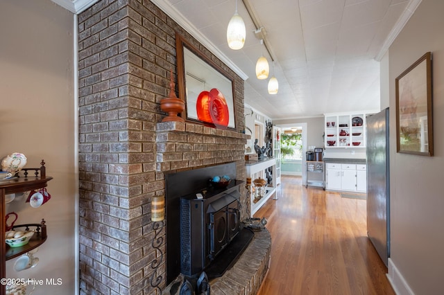 living area featuring baseboards, wood finished floors, and crown molding