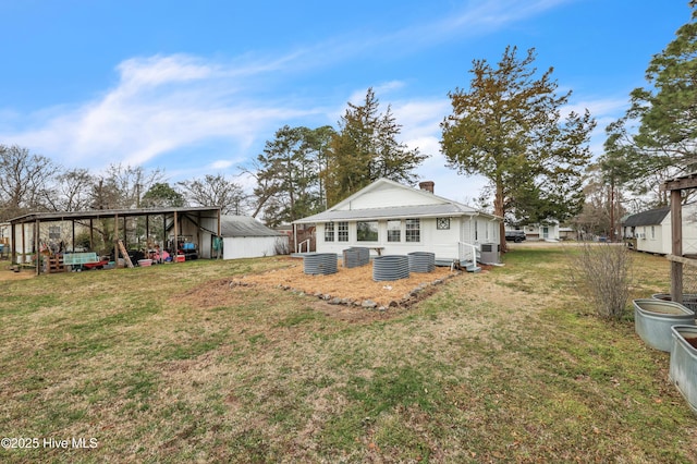 back of house with an outbuilding, central air condition unit, a chimney, and a yard