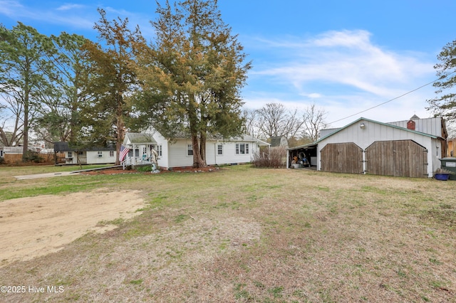 view of yard featuring an outbuilding, a detached garage, an outdoor structure, and dirt driveway