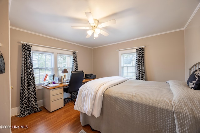 bedroom with multiple windows, crown molding, and light wood-style floors