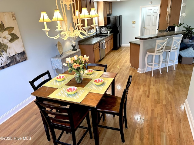 dining room featuring light wood-style flooring and baseboards