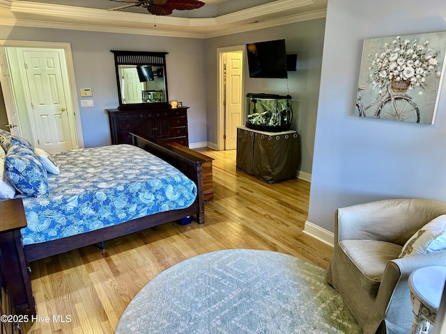 bedroom featuring crown molding, baseboards, and wood finished floors