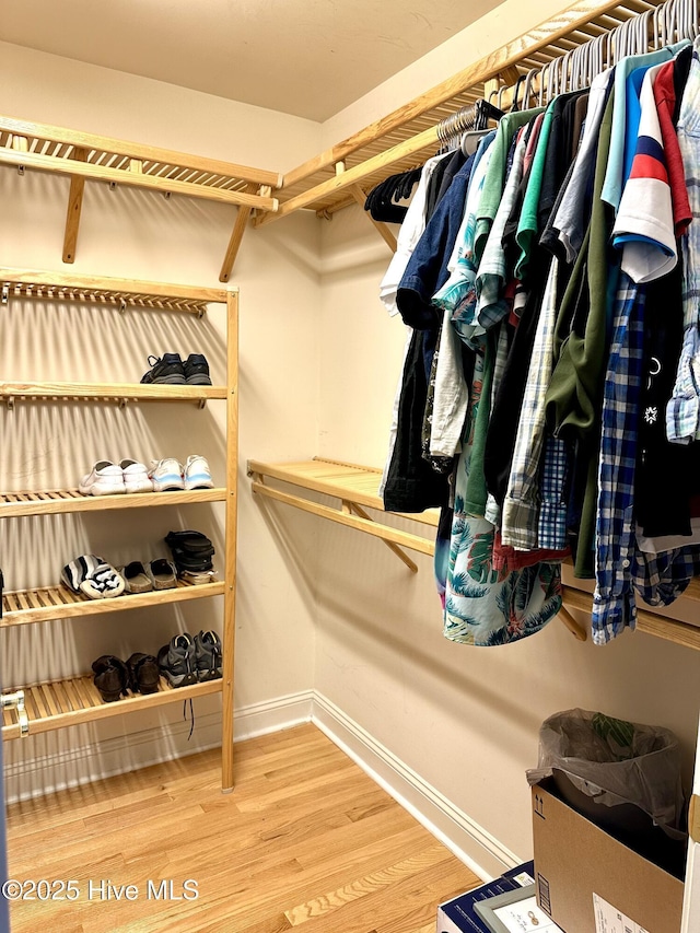 walk in closet with wood finished floors