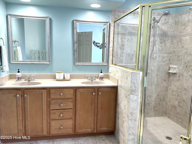 full bathroom featuring double vanity, a stall shower, and a sink