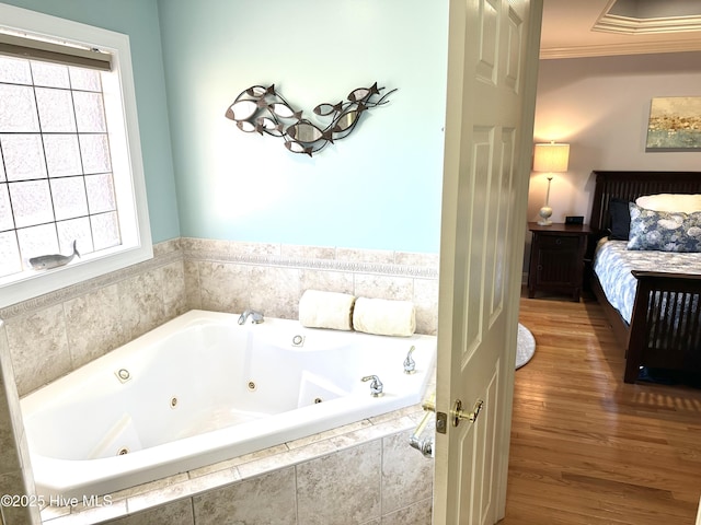 full bath with a jetted tub, wood finished floors, crown molding, and ensuite bathroom