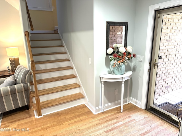 staircase with baseboards and wood finished floors