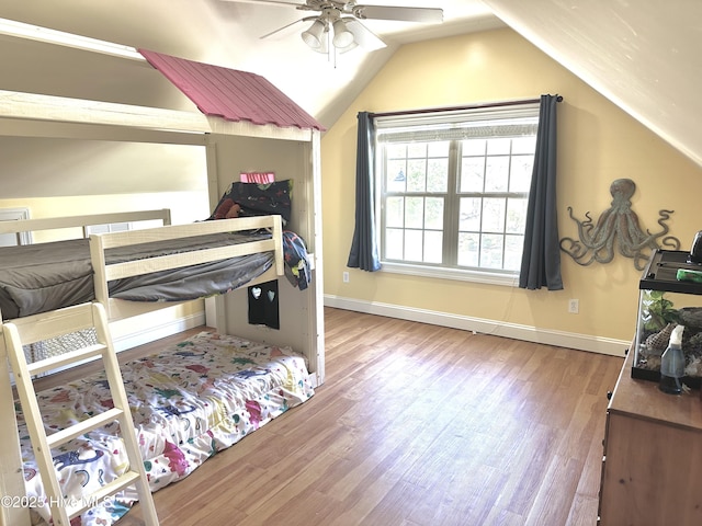 bedroom featuring lofted ceiling, ceiling fan, wood finished floors, and baseboards