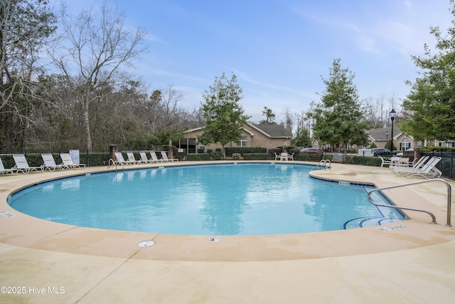 community pool with fence and a patio