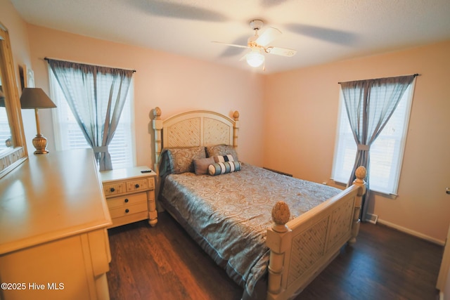 bedroom with dark wood finished floors, a ceiling fan, and baseboards