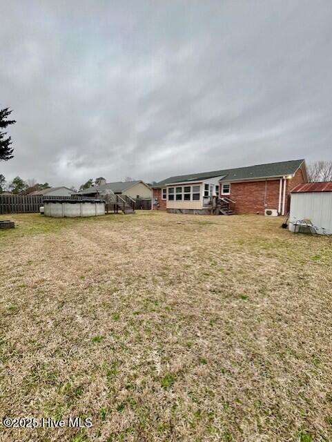 view of yard featuring fence and a pool