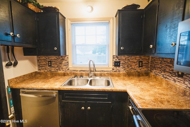 kitchen with a sink, dark cabinets, tasteful backsplash, and stainless steel dishwasher