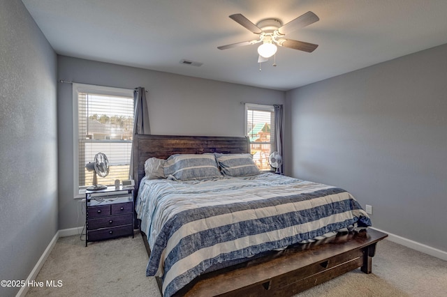 bedroom with baseboards, visible vents, and light colored carpet